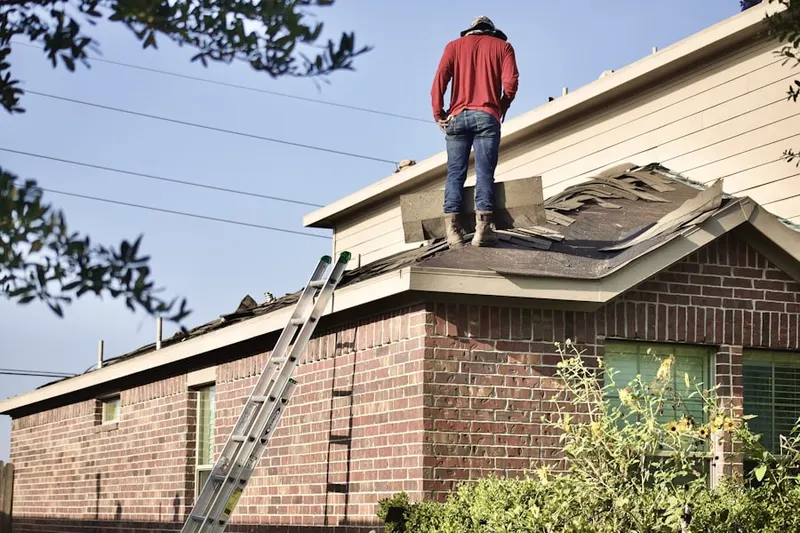 Professional roofer working on a residential roof in Avon
